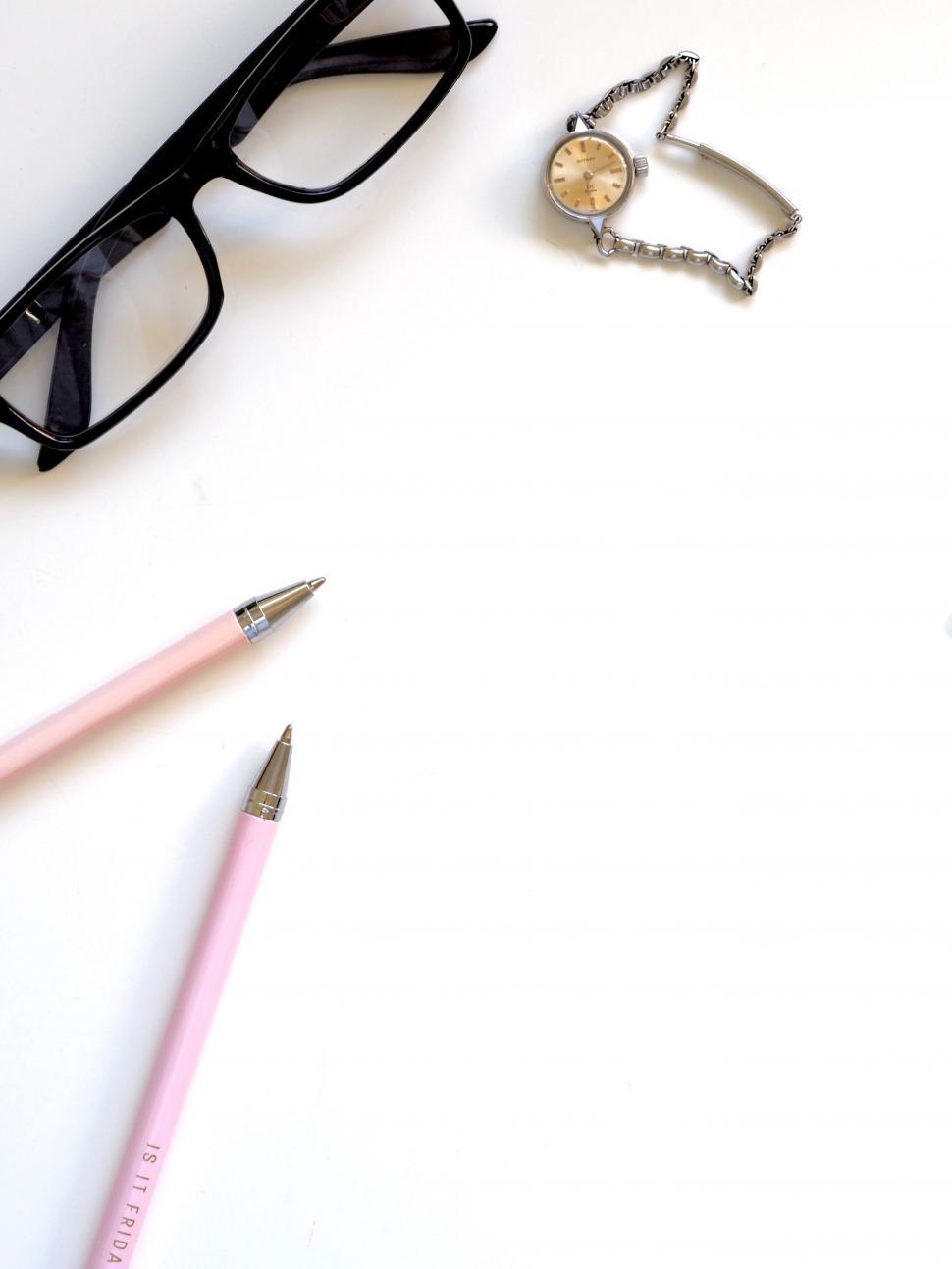 Free Image of Eyeglasses and stationery on white background 