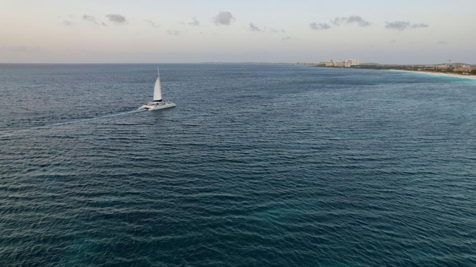 Free Image of Sailboat cruising near shore at dusk 