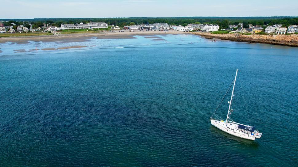 Free Image of Yacht sailing near coastal town in daylight 
