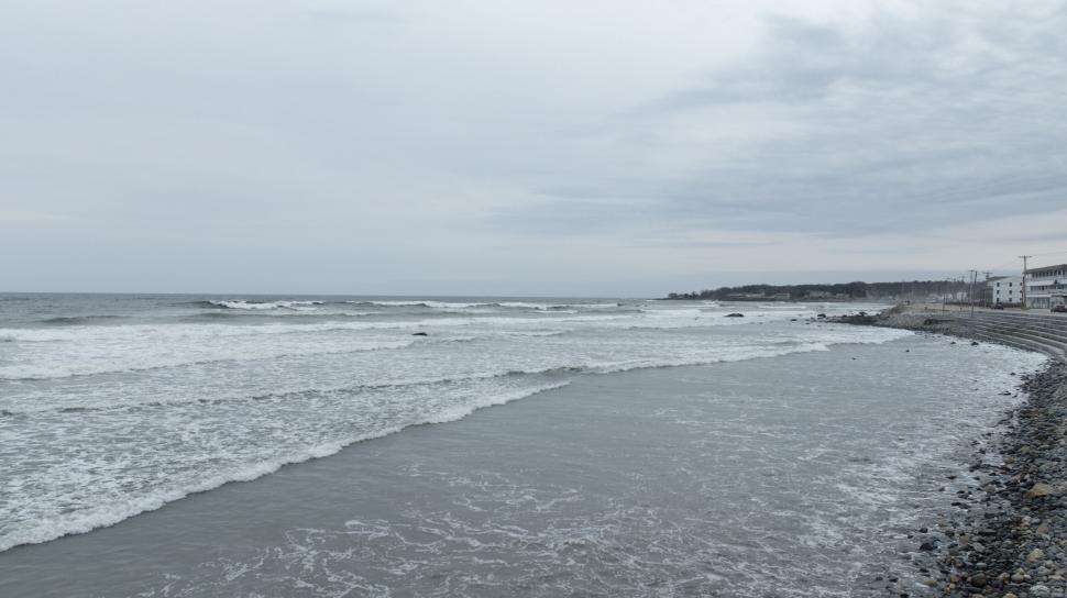 Free Image of Beach with gentle waves and cloudy sky 