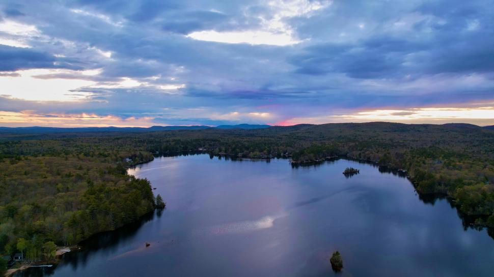 Free Image of Sunset over a calm lake with forest 