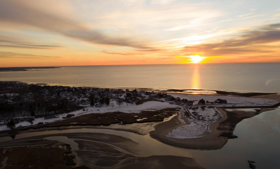 Free Image of Sunset over a snowy coastal landscape 