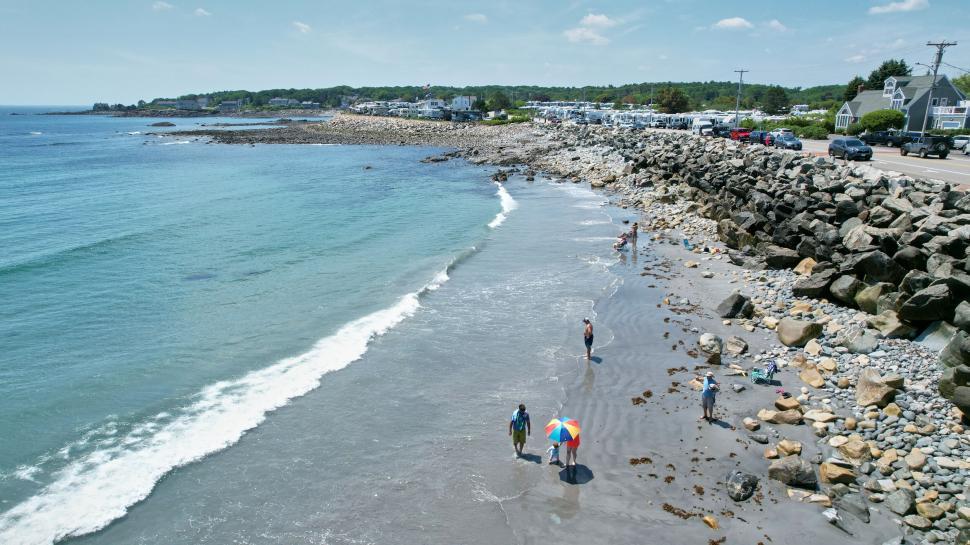 Free Image of Beach scene with people and rocky shoreline 