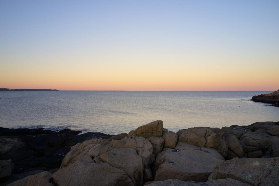 Free Image of Tranquil seaside sunset with rocky shore 