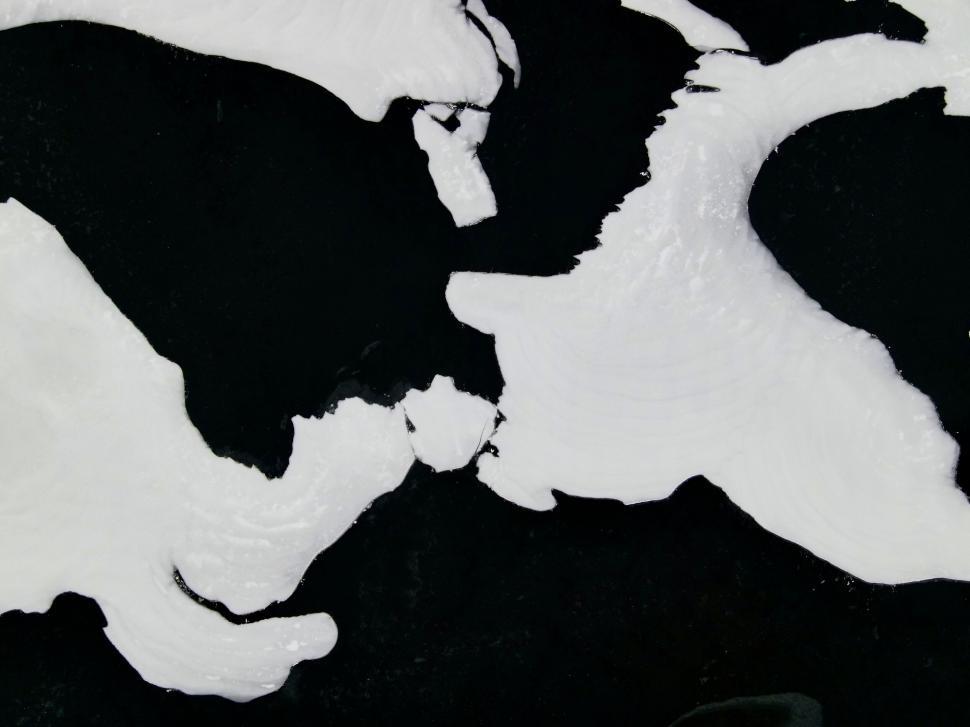 Free Image of Aerial view of snow on dark waters 