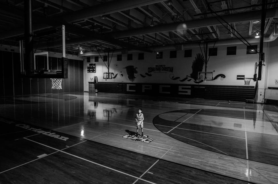 Free Image of Lonely player in an empty basketball gym 