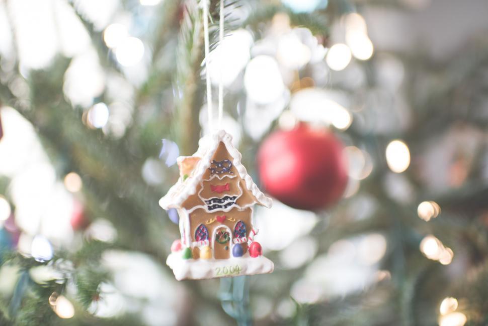 Free Image of Gingerbread house ornament on Christmas tree 