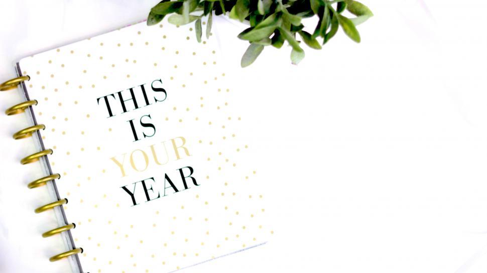 Free Image of Open planner with motivational quote on desk 