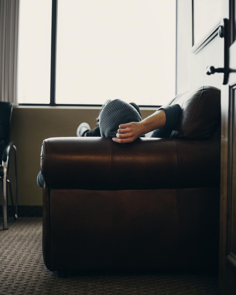 Free Image of Person reclining on a leather sofa 
