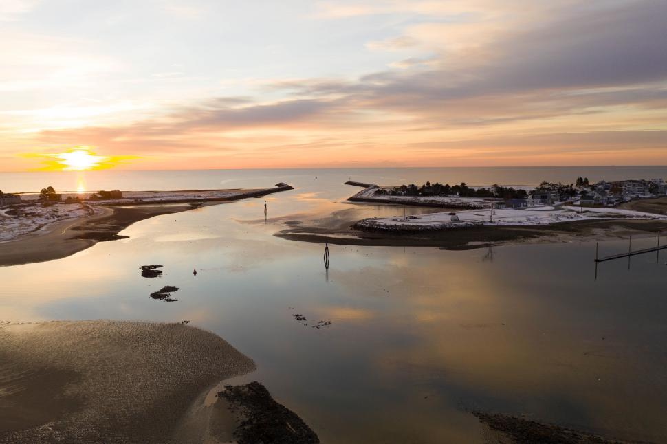 Free Image of Sunset over calm waters with land and reflections. 