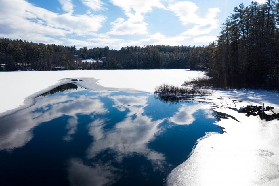 Free Image of Snow-covered lake with clear reflection under blue sky. 