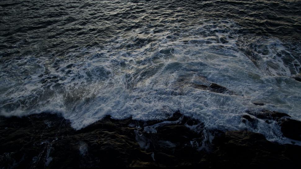 Free Image of Waves crashing on rocky shore during dusk or dawn 