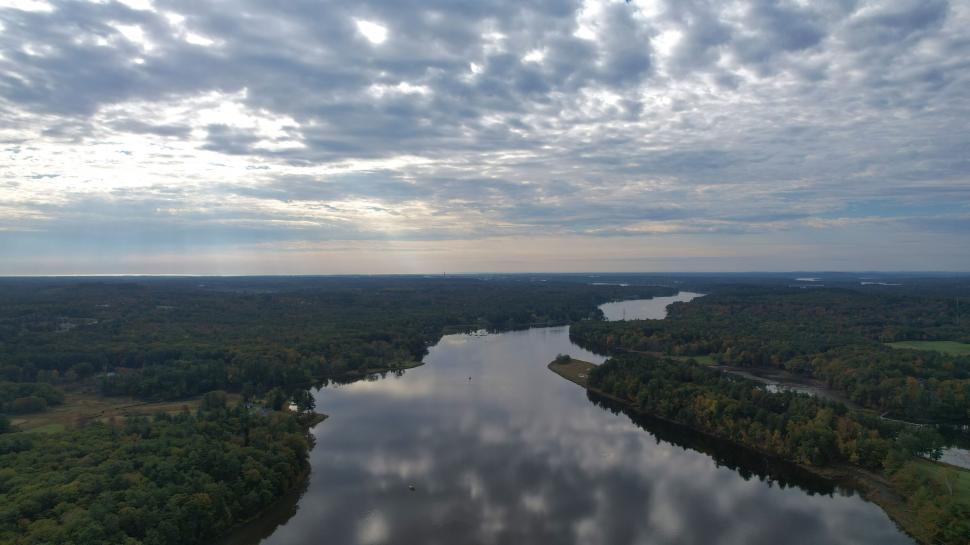 Free Image of River winding through forest under a dramatic sky 