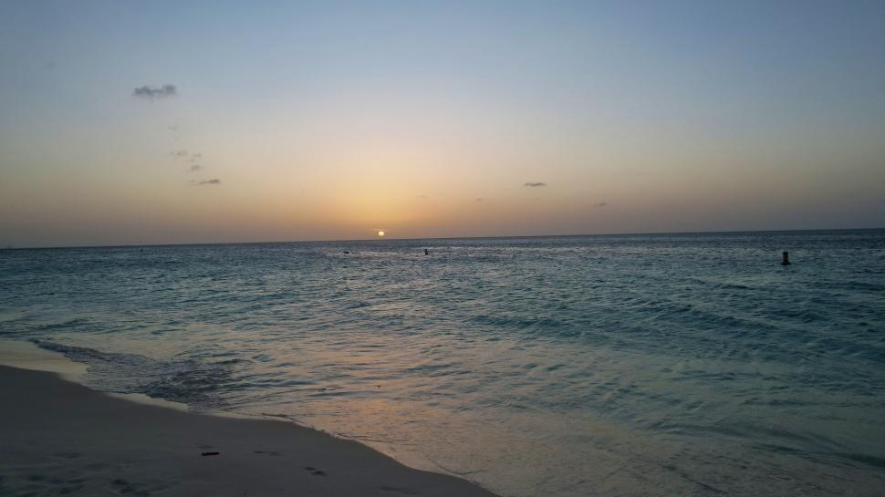 Free Image of Sunset over serene ocean waves on a tranquil evening 