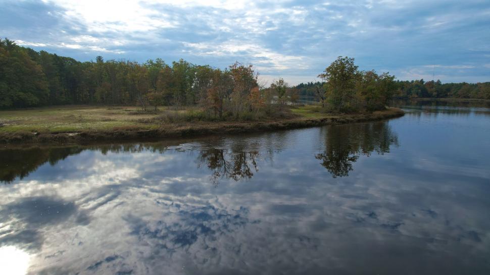 Free Image of Peaceful riverbank with autumn forest reflection 