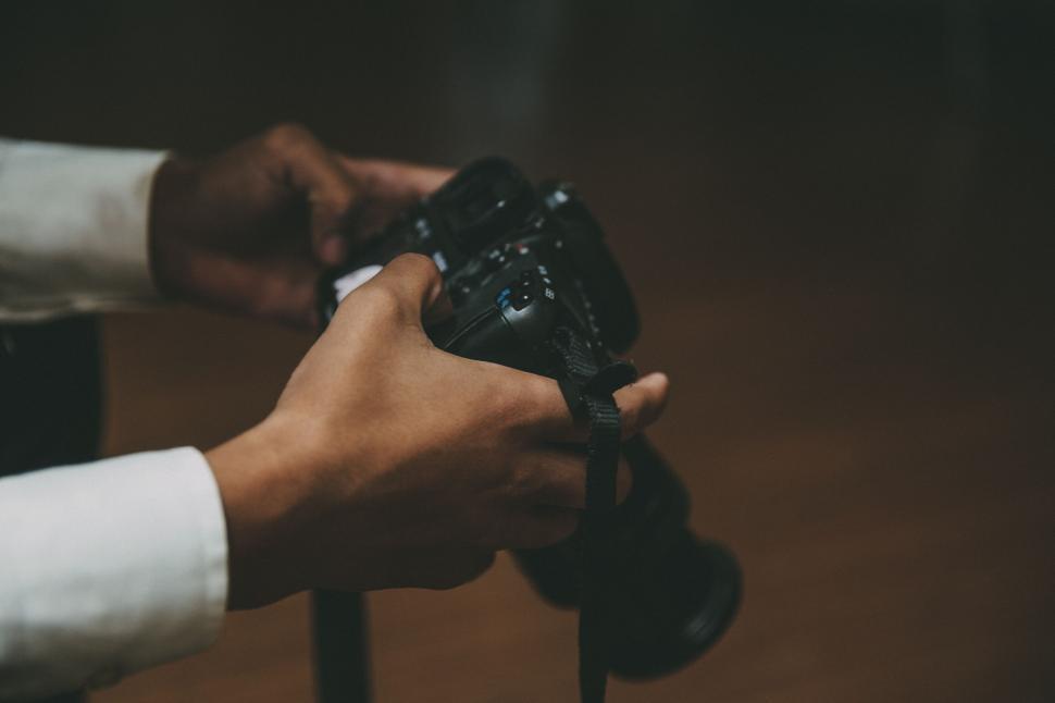 Free Image of Person holding a professional camera indoors close up. 