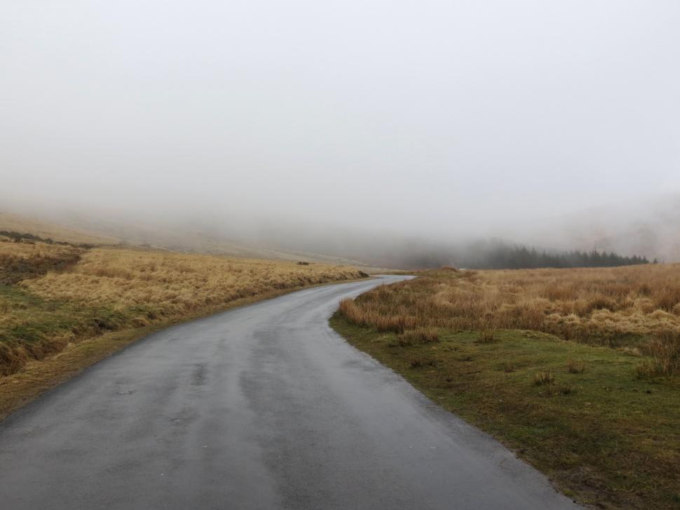 Free Image of Lonely road winding through foggy countryside landscape. 