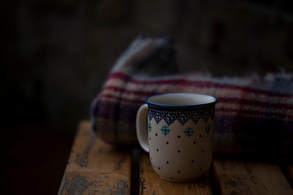 Free Image of Cozy ceramic mug with rustic plaid blanket backdrop 