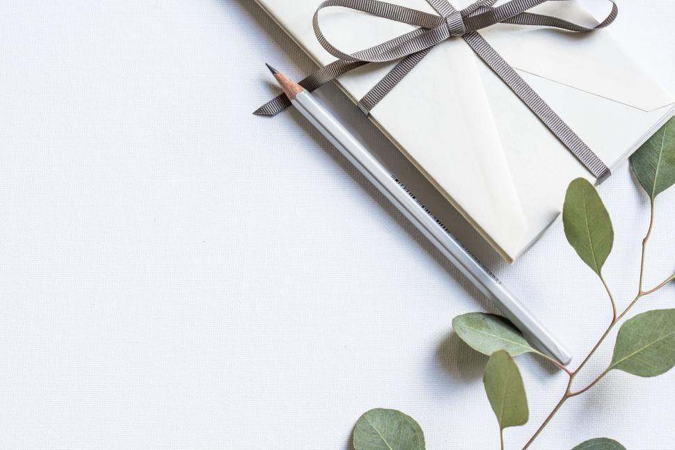 Free Image of Elegant card and pencil arrangement with green leaves 