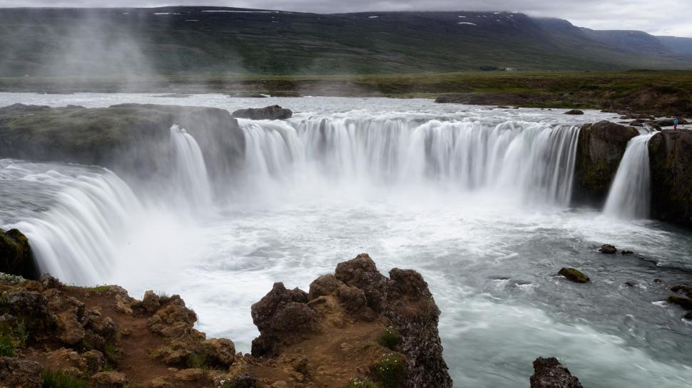Free Image of Stunning waterfall cascading in a serene landscape view 