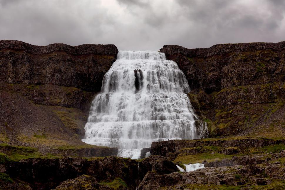 Free Image of Powerful waterfall cascading down rocky cliffs dramatic view. 