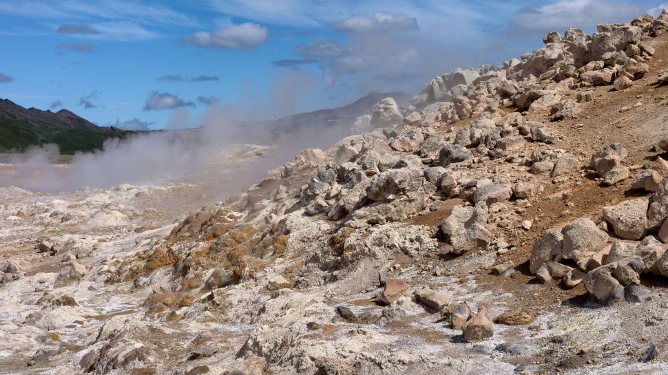 Free Image of Rocky geothermal landscape with steam rising into sky 