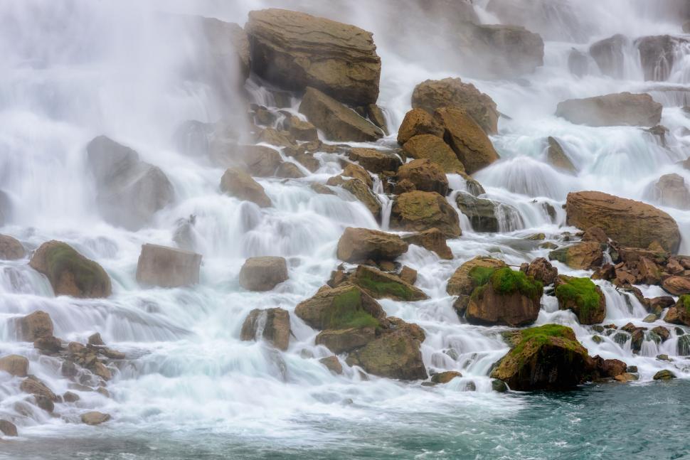 Free Image of Cascading water over rocks with mist in background. 
