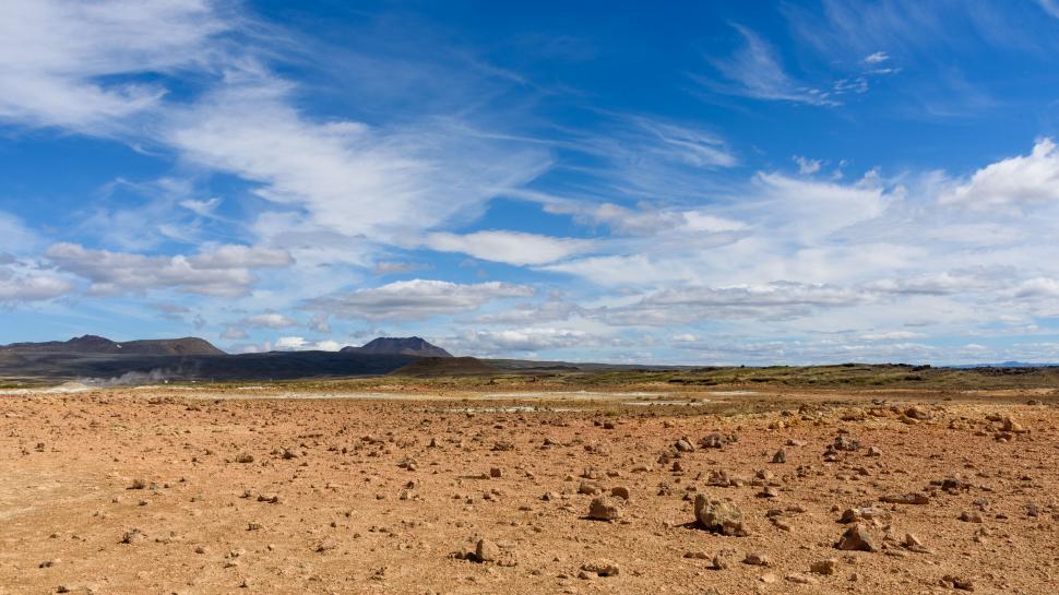 Free Image of Vast desert landscape with distant mountains under sky. 