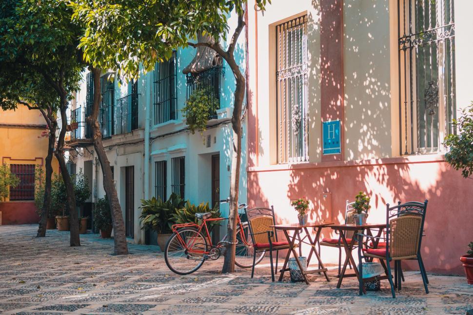 Free Image of Cozy outdoor cafe seating area with bikes in sunny courtyard. 