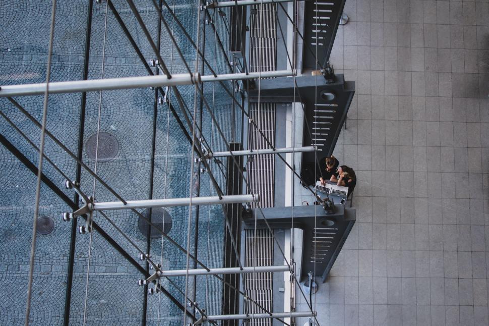 Free Image of Looking down through modern structure onto people below. 