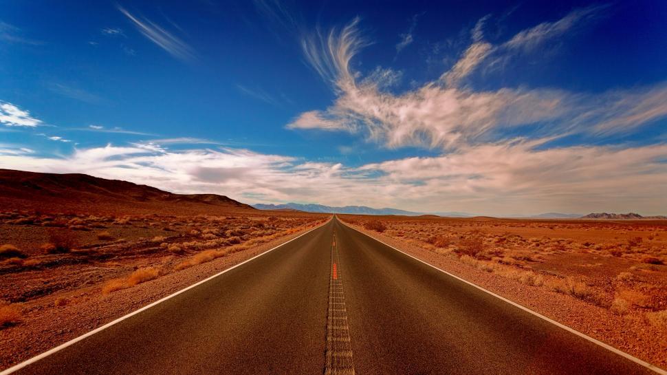 Free Image of Endless straight road through barren desert landscape. 