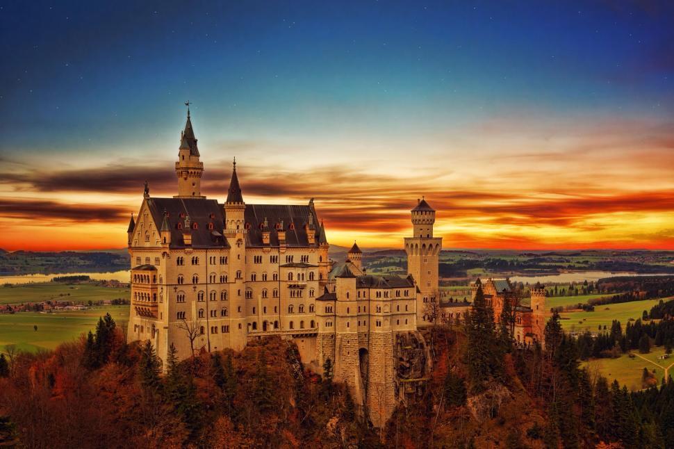 Free Image of Majestic castle on hilltop with vivid sunset background 