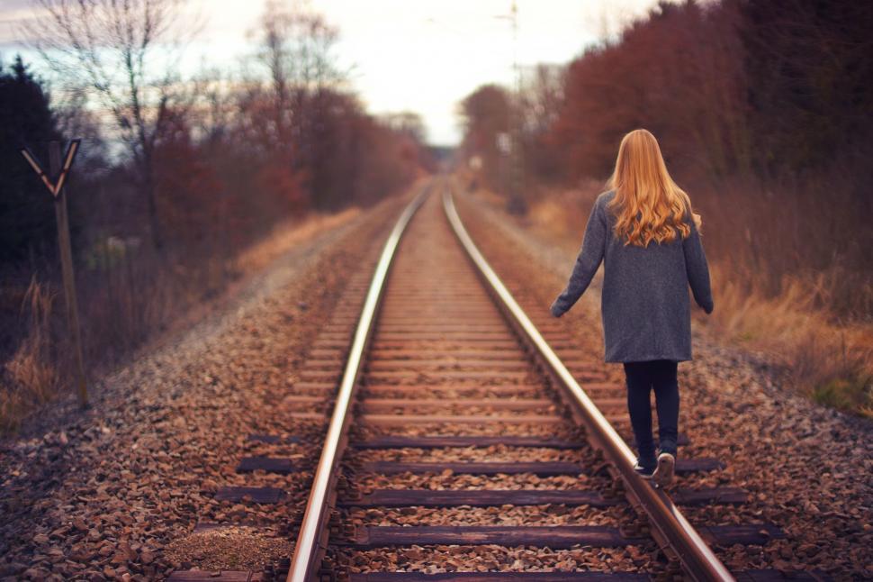 Free Image of Girl walking on railway track in autumn countryside. 