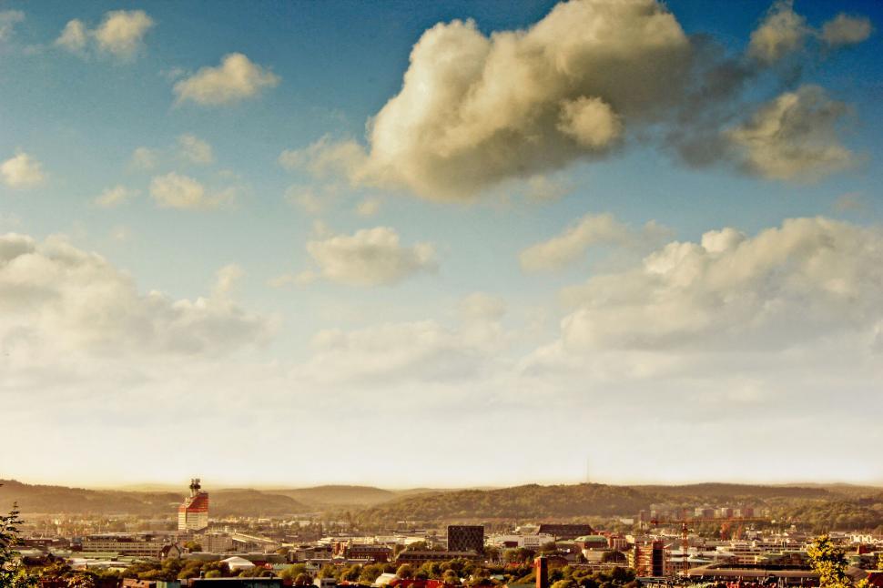 Free Image of Cityscape view with a sky filled with fluffy clouds 