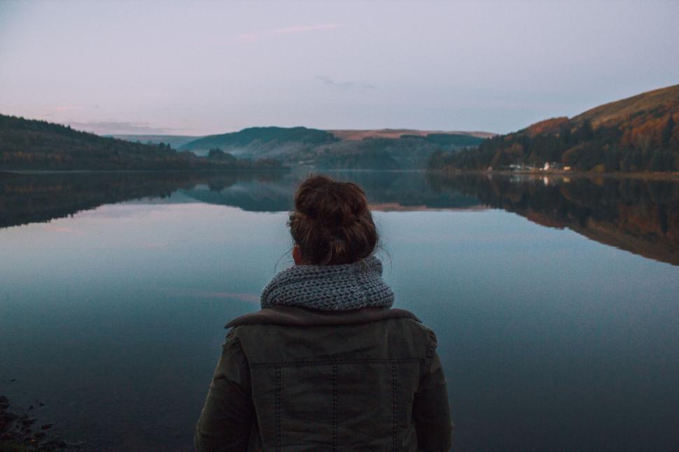 Free Image of Rear view of a woman gazing at mountains across a lake 