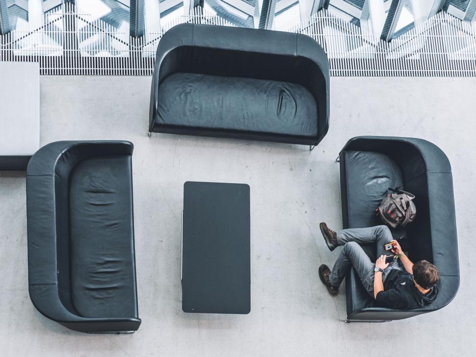 Free Image of Empty lounge area with black couches and a table. 