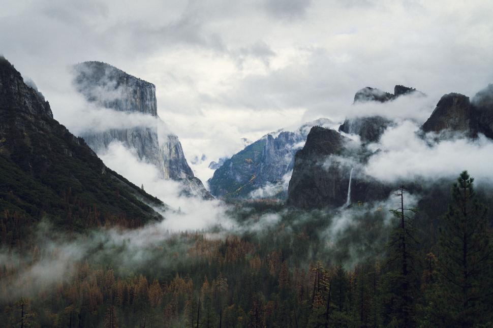 Free Image of Foggy mountain range with visible trees and valleys. 
