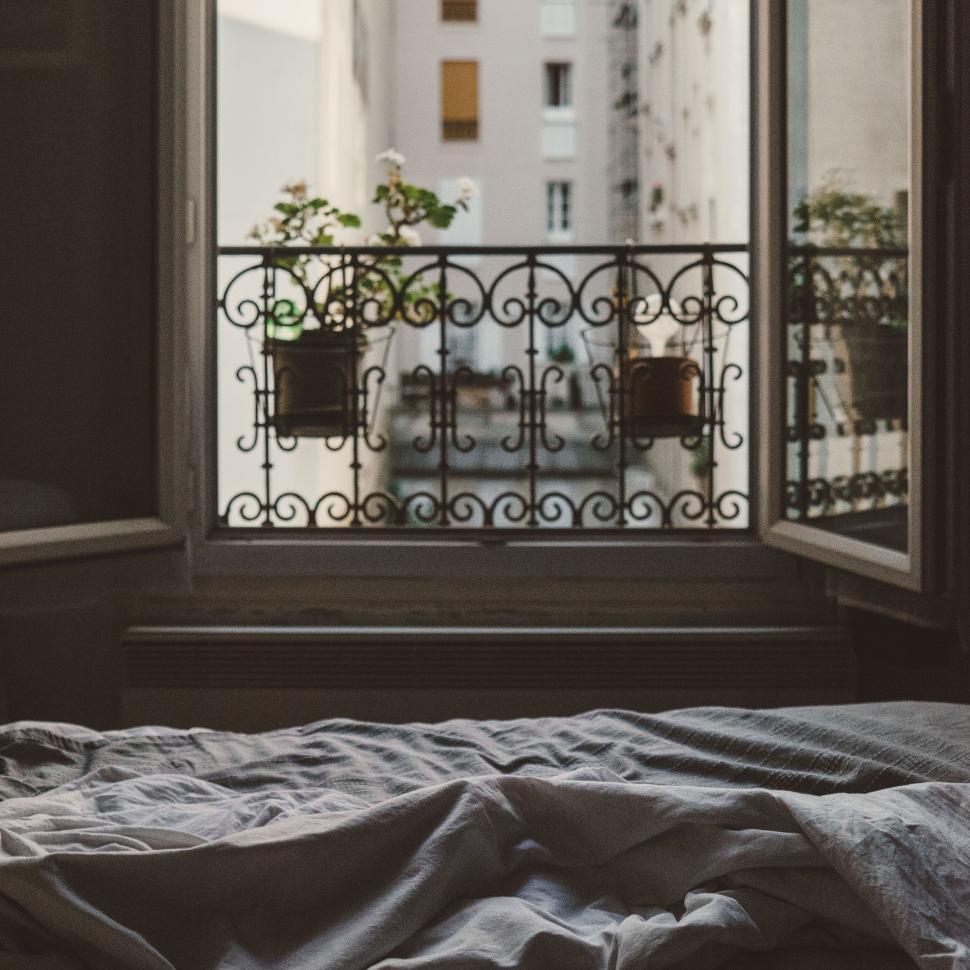Free Image of Cozy bedroom with open window viewed on a rainy day. 