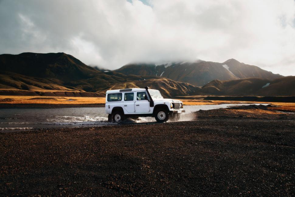 Free Image of An off-road vehicle crossing a shallow river 