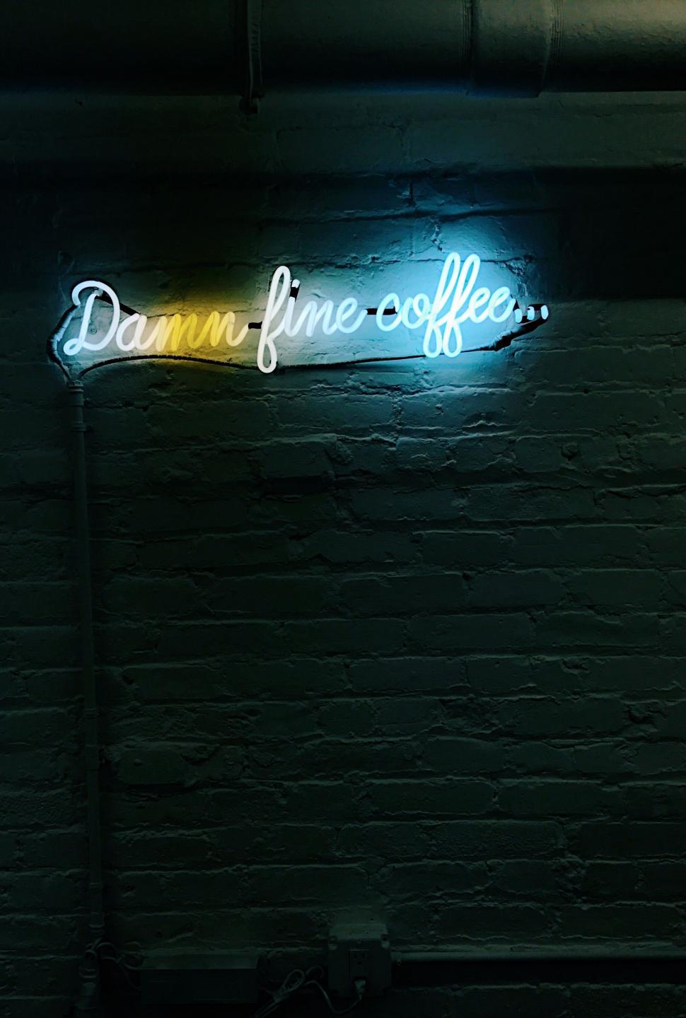 Free Image of Neon sign saying Damn fine coffee against a dark wall 