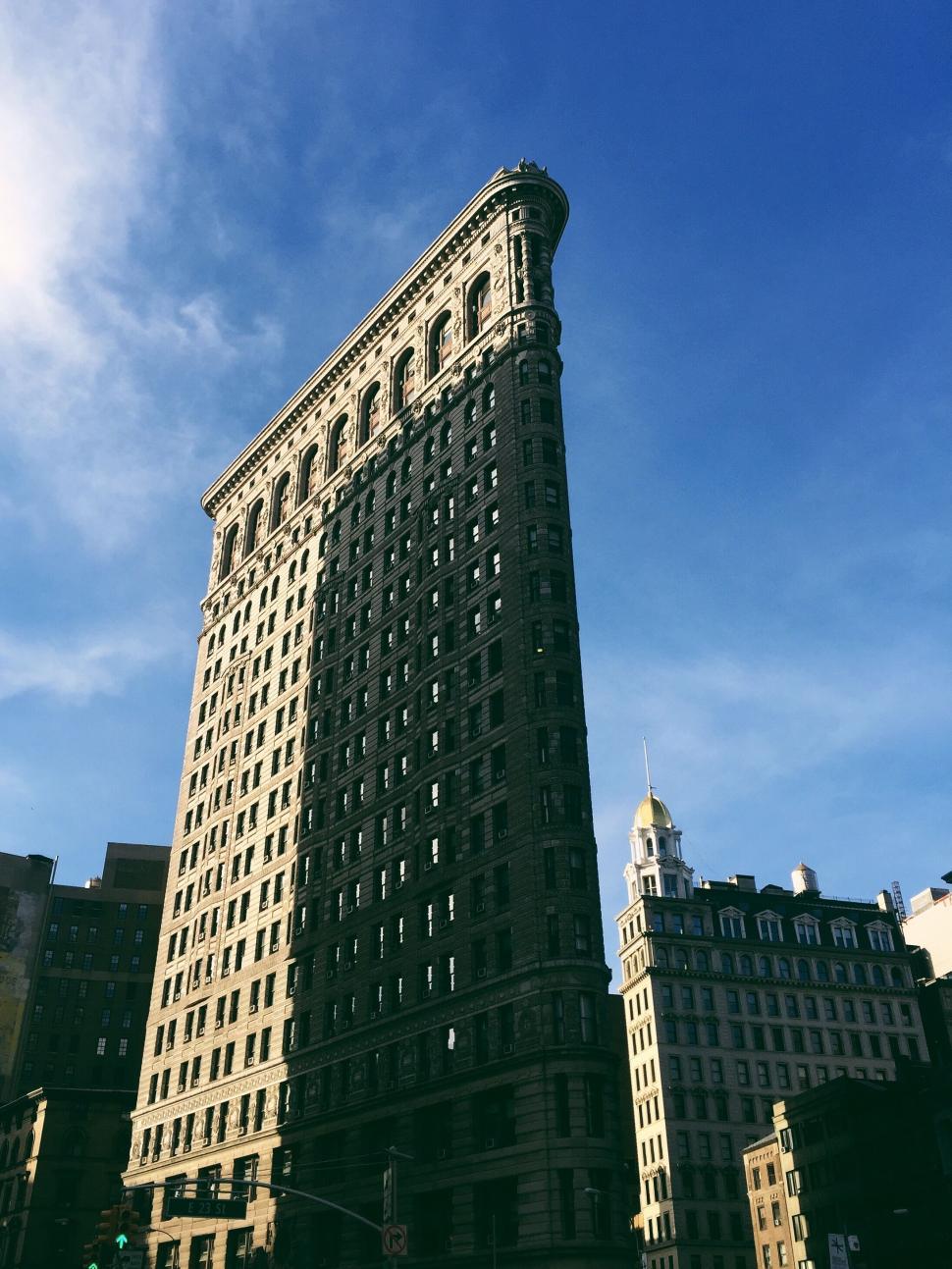 Free Image of Tall and thin skyscraper under a clear blue sky view 