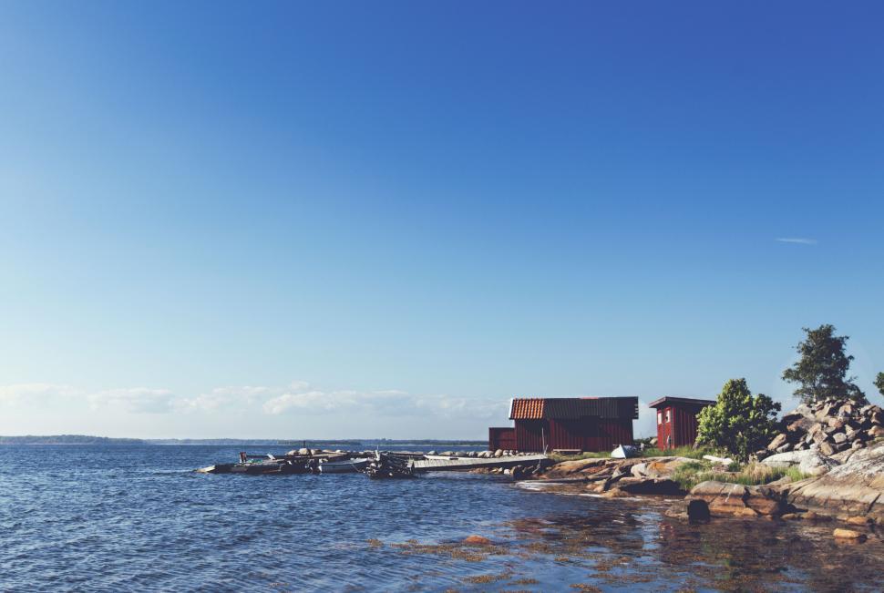 Free Image of Coastal scene with small wooden shelters by the seaside 