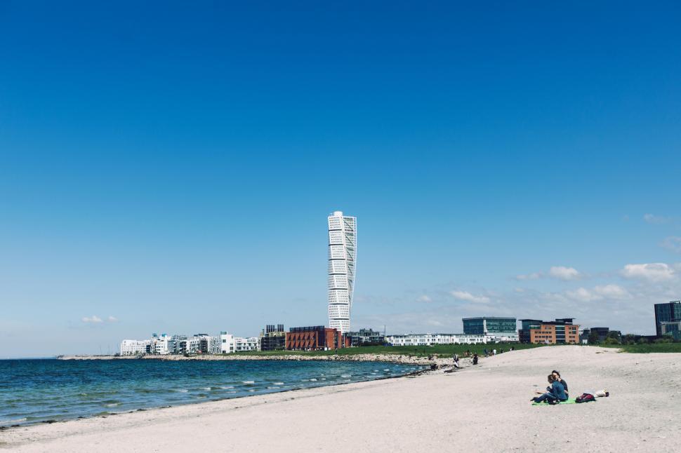 Free Image of Sunny beach with coastal city buildings and sea view 
