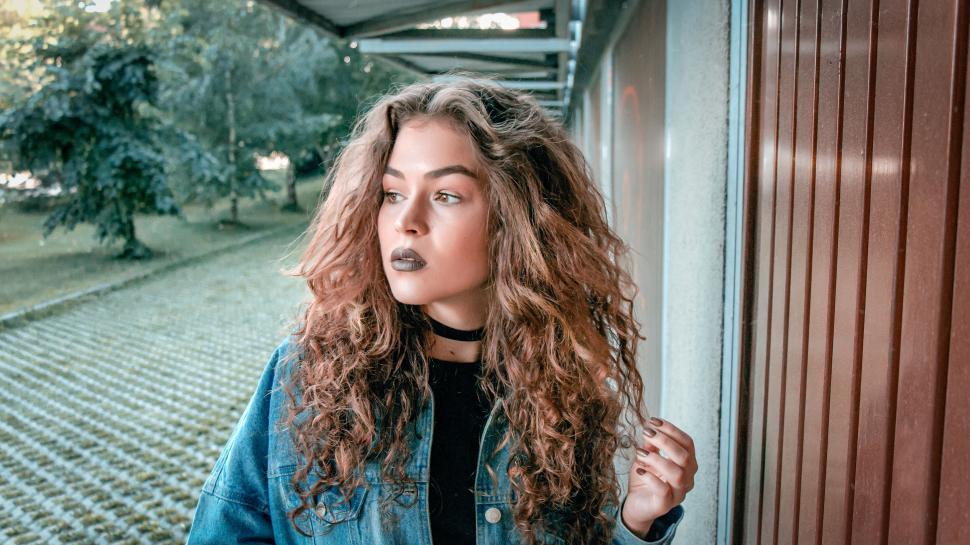 Free Image of Person in denim jacket outdoors with wavy hair 