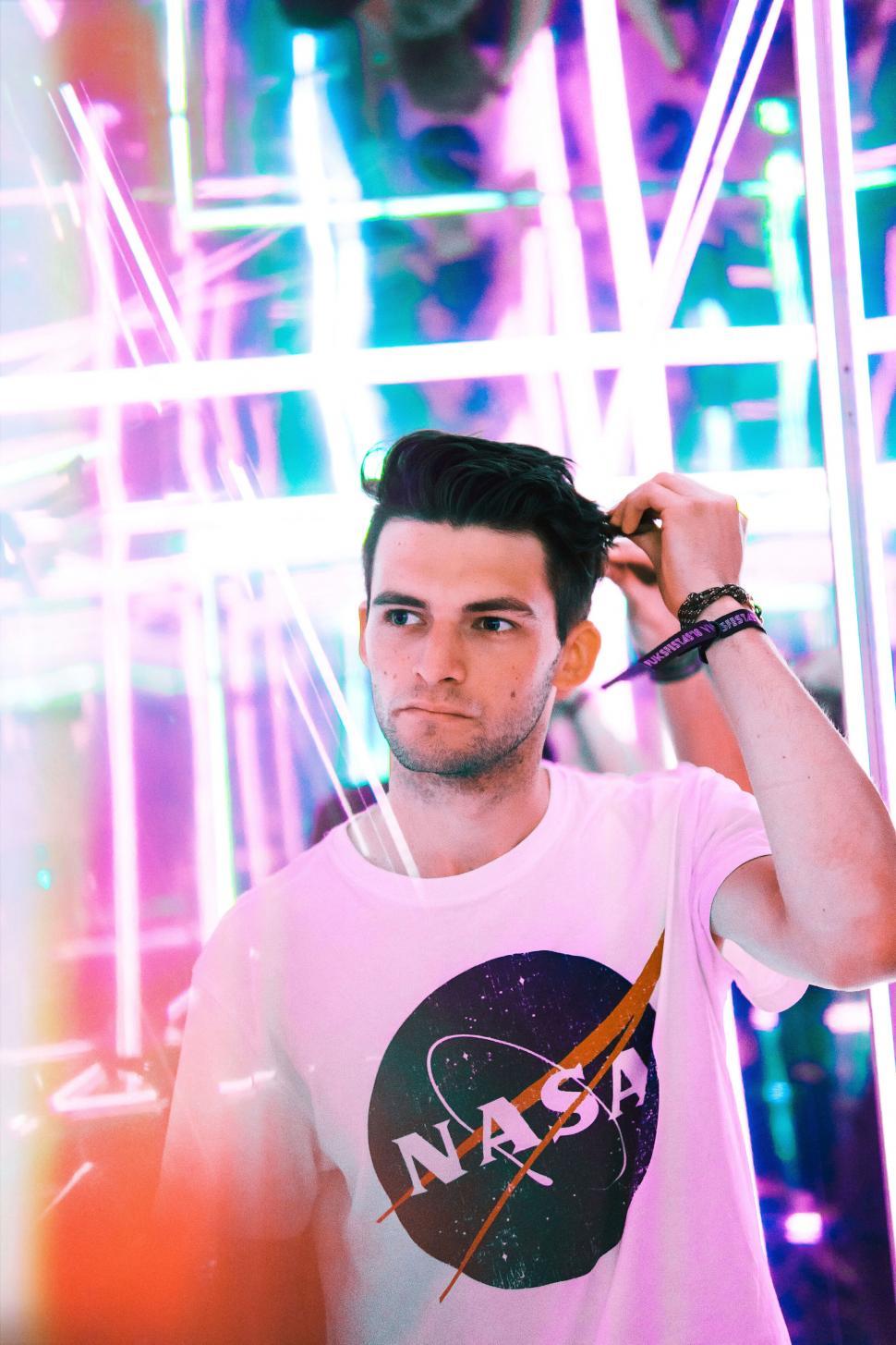 Free Image of Person standing indoors under neon lights, casual wear 