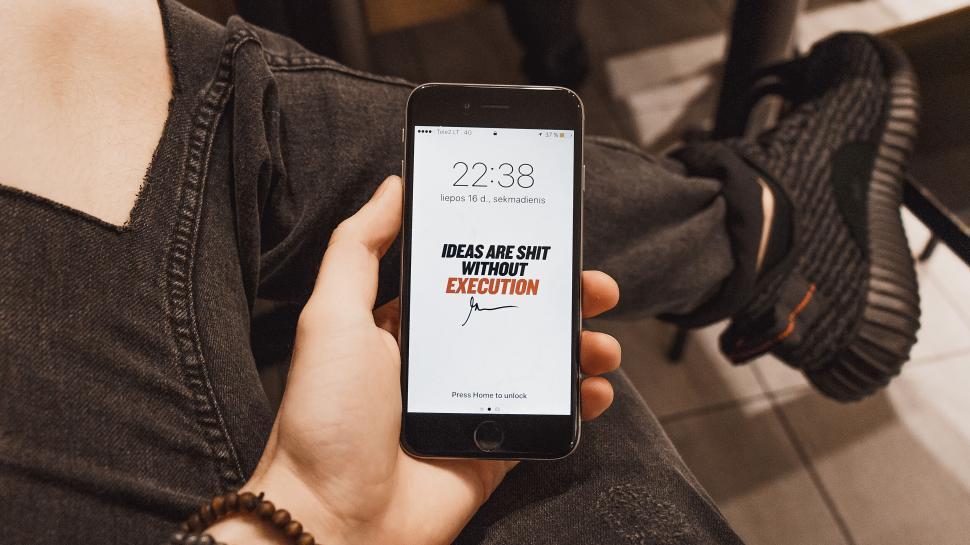 Free Image of Hand holding smartphone with motivational quote on screen 