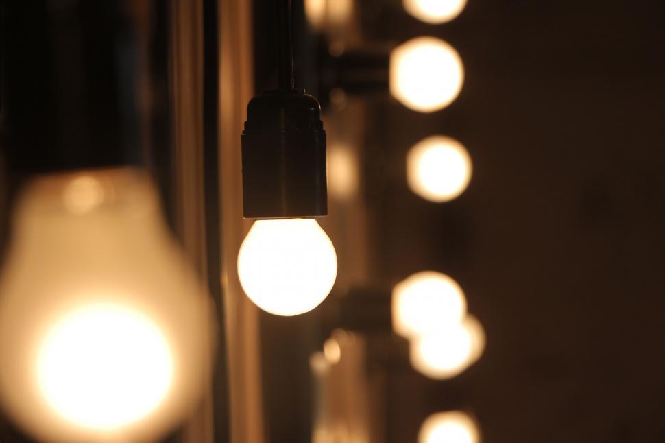 Free Image of Row of illuminated bulbs against a dark blurry background. 