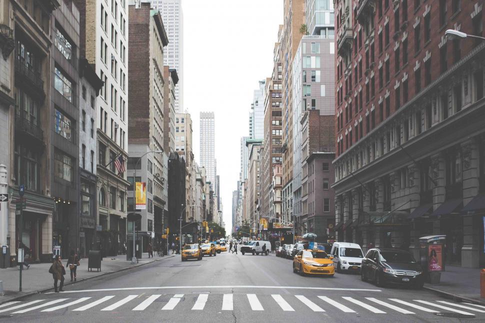 Free Image of Urban street scene with tall buildings and taxis 