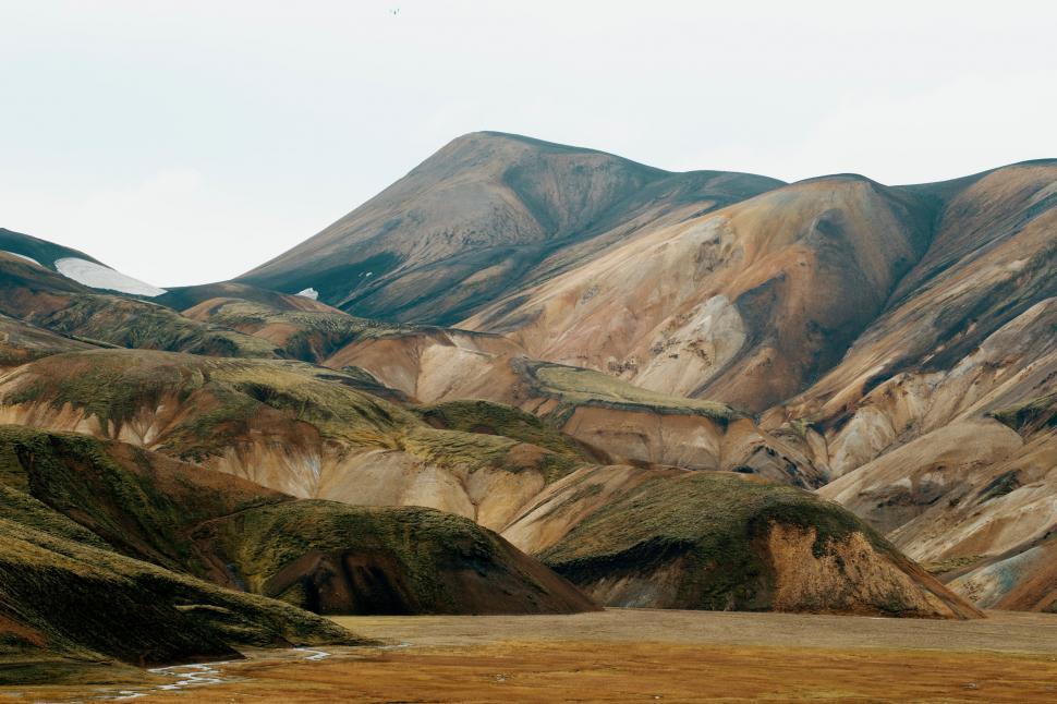 Free Image of Mountain range with diverse colors and rugged terrain 