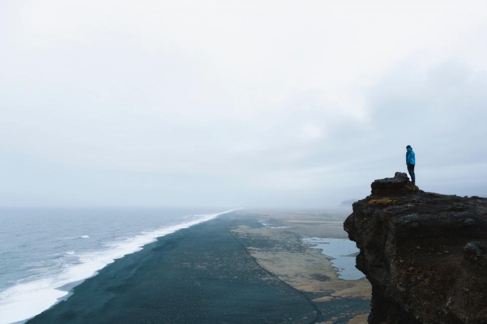 Free Image of Person on cliff overlooking vast coastline and ocean 